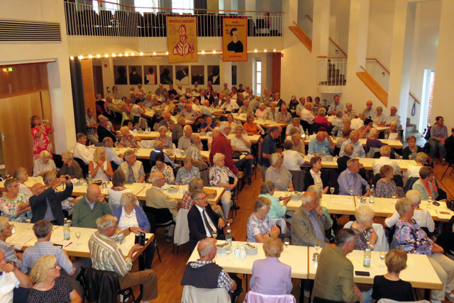 Blick in den voll besetzten Saal des B&uuml;rgerhauses Telgte, der mit den Bannern der Grafschaft Glatz geschm&uuml;ckt war.